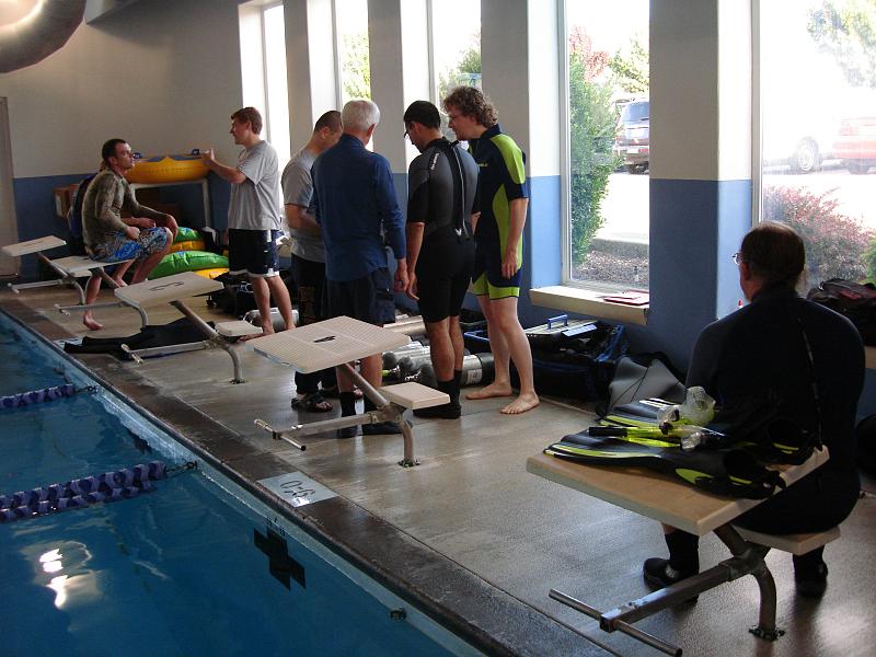 DSC02255 This is the third pool session of the course. Today we will be using full-body, thick wetsuits. Our instructors are giving us some briefing before we start setting up the scuba equipment.